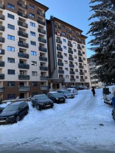 a parking lot with cars parked in the snow at Apartman Nikola in Zlatibor