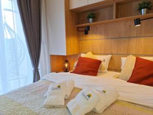 Un dormitorio con una cama grande con toallas. en Vistanova Milmari S33, en Kopaonik 36 fotos más