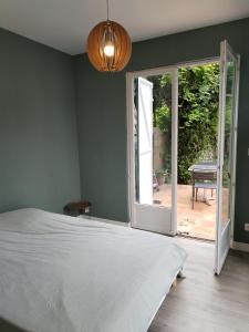 ein Schlafzimmer mit einem Bett und einer offenen Tür in der Unterkunft Campagne à côté de Paris in Romainville + 4 Fotos