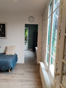 ein Schlafzimmer mit einem Bett und einem großen Fenster in der Unterkunft Campagne à côté de Paris in Romainville