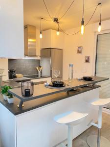 a kitchen with a counter with two stools at Le Cosy De l'Ourcq T2 40m2 20 min de Paris in Villepinte