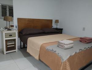 a bedroom with a bed with two towels on it at Alquileres Allen in Allen
