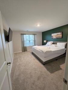 a bedroom with a large bed with a green wall at Elizabethtown Charm in Elizabethtown