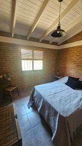 a bedroom with a large bed in a brick wall at Los Chivos in Villa Cura Brochero +12 photos