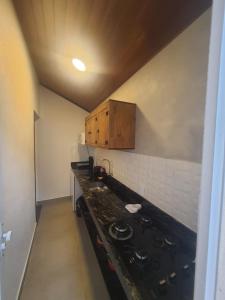 a kitchen with a black stove top oven at Suítes Quintal de Lázaro 4 in Ubatuba +27 photos