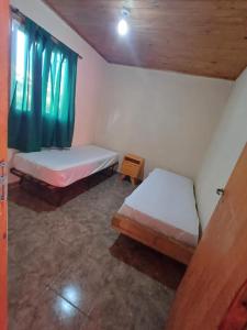 two beds in a small room with a window at Casa quinta Capibara in Concepción del Uruguay