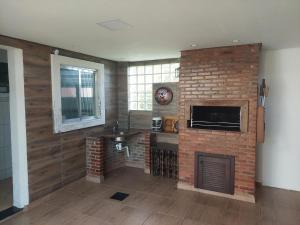 a living room with a brick fireplace and a television at Sobrado pertinho da praia in Capão da Canoa