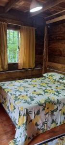 a bedroom with a bed with a floral comforter at Sitio Holistico Natureza Sanadora in Morro Reuter