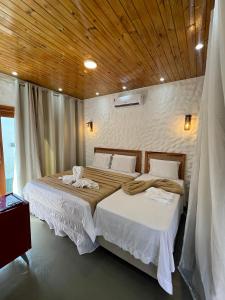 a bedroom with two beds and a wooden ceiling at Kanto do Chico Prime in Icaraí +35 photos