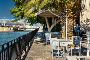 a patio with tables and chairs next to the water at Chalkida Spacious Flat with amazing view! in Chalkida