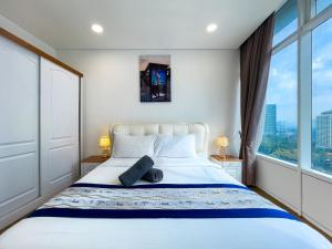 sypialnia z białym łóżkiem i dużym oknem w obiekcie Vortex Suites klcc By Sky House w Kuala Lumpur