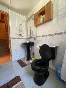 Un baño con un inodoro negro y un lavabo. en Casa con vista a Futaleufú, en Futaleufú 20 fotos más