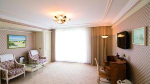 a room with a large window with chairs and a table at Seeschlößchen - Hotel Strandperle in Cuxhaven