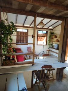 un salon avec une grande table et des chaises dans l'établissement Cumbuca Hostel, à Porto Seguro
