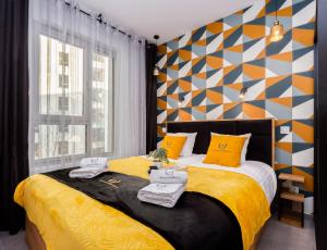 1 dormitorio con 1 cama con sábanas amarillas y almohadas amarillas en ApartamentyGdansk EU - ŻURAWIE I, en Gdansk