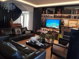 a living room with a couch and a television at Lyon 4e Croix Rousse Maison complète Jardin in Lyon