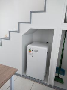 a small white refrigerator in a room with stairs at Petrohue I in Valdivia
