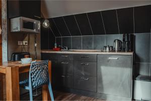 a kitchen with gray cabinets and a table and a sink at HeinrichsOase 13 - Bielefeld Mitte in Bielefeld