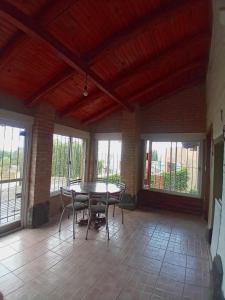 a dining room with a table and chairs and windows at Casa en Rumipal de 4 a 11 personas in Villa Rumipal +3 photos
