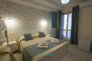 Un dormitorio con una cama con toallas. en Villa Letizia - Sky blu pompei room, en Boscoreale