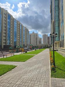 einen Ziegelsteinweg in einer Stadt mit hohen Gebäuden in der Unterkunft Апартаменты Астаны in Astana