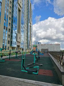 ein Spielplatz in einer Stadt mit hohen Gebäuden in der Unterkunft Апартаменты Астаны in Astana + 2 Fotos