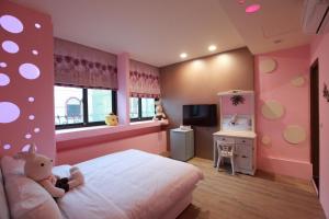 Un dormitorio rosa con una cama con un osito de peluche. en Fasiter B&B train station en Hualien