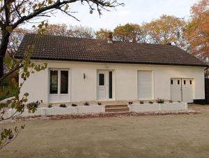 a white house with a white fence in front of it at Parenthèse en Terre Breizh in Bohal