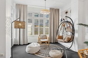 a living room with a chair and a swing at maremar - Verden's Finest - 134qm - 2 Schlafzimmer - Luxus Boxspring - Küche - Arbeitsplätze & Highspeed WLAN - Terrasse in Verden