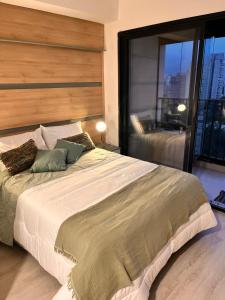 a bedroom with a large bed with a large window at Petit Green Paradise in São Paulo +10 photos