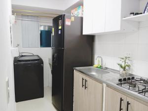 a kitchen with a black refrigerator and a sink at Apto 3 habit +2TV-Wifi, Netflix-Parqueadero gratis in Barranquilla