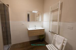 baño con lavabo, espejo y silla en Villa Letizia - luxury Sorrento room, en Boscoreale 4 fotos más