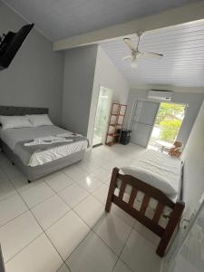 a bedroom with two beds and a ceiling fan at Pousada e casa Villa Siri in Ubatuba