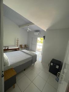 a bedroom with a bed and a table in it at Pousada e casa Villa Siri in Ubatuba