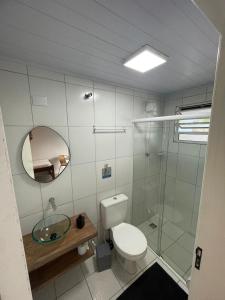 a bathroom with a toilet and a sink and a mirror at Pousada e casa Villa Siri in Ubatuba