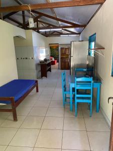 a kitchen with a table and blue chairs and a refrigerator at Casa Colorida in Prado +6 photos