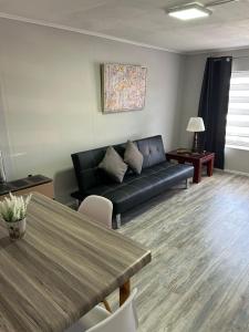 a living room with a black couch and a table at Kau in Punta Arenas