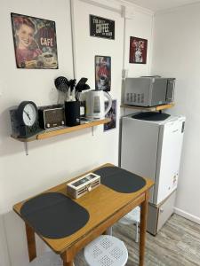 a room with a table with a microwave and a refrigerator at Kau in Punta Arenas