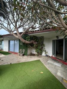 a house with a green lawn in front of it at La Casona el Encanto in El Quisco