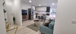 a living room with a couch and a kitchen at Charming little house in Paul do Mar