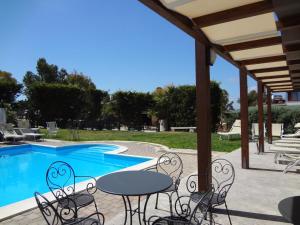 a patio with tables and chairs next to a swimming pool at Agriturismo Vultaggio in Guarrato