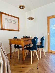 un tavolo in legno con 4 sedie in una stanza di Appartamento Il Pungitopo ad Abetone