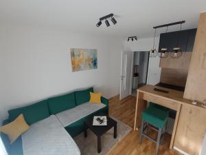 a living room with a green couch and a table at Stan na dan Nina Plus - Pale Centar in Pale