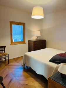 una camera da letto con un letto, un comò e una finestra di Appartamento Il Pungitopo ad Abetone Altre 18 foto