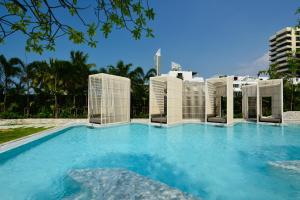 uma grande piscina com edifícios ao fundo em Veranda Resort Pattaya - MGallery by Sofitel em Praia de Jomtien