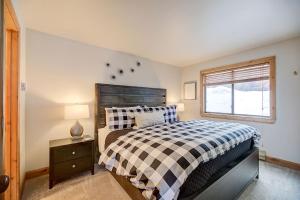 ein Schlafzimmer mit einem Bett mit einer karierten Decke und einem Fenster in der Unterkunft Pinetree Retreat - Hot Tub, Heated Pool & Sauna - 6 Min Walk to Lift & Dining in Park City + 7 Fotos