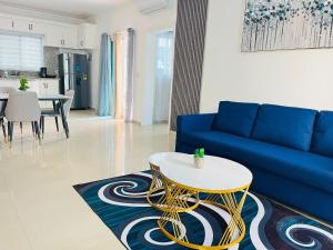 un soggiorno con un divano blu e un tavolo di Cozy condo 290m distance from the beach a Punta Cana