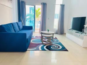 un soggiorno con un divano blu e un tavolo di Cozy condo 290m distance from the beach a Punta Cana