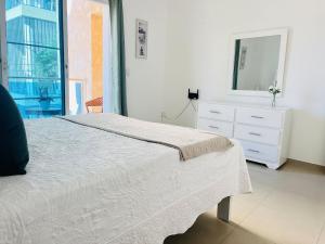 una camera da letto con un letto, un comò e uno specchio di Cozy condo 290m distance from the beach a Punta Cana Altre 15 foto