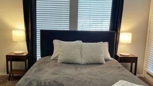 a bedroom with a bed with two lamps on two tables at Spacious Family Value Retreat with Pool & Garage in Corpus Christi +16 photos